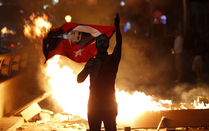 An anti-government protester holds a Turkish national flag with a portrait of Mustafa Kemal Ataturk, founder of modern Turkey, on it during a demonstration in Ankara
